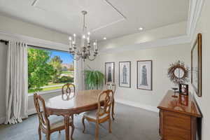 Dining room with carpet flooring, a chandelier, and recessed lighting