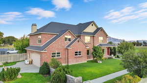 View of front of house featuring brick siding, concrete driveway, a chimney, an attached garage, and roof with shingles