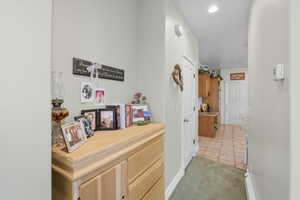 Corridor featuring light tile patterned flooring, light colored carpet, and recessed lighting