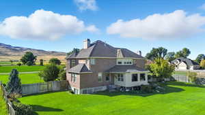Back of property featuring a chimney, a fenced backyard, and brick siding