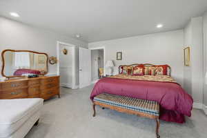 Bedroom with recessed lighting, light carpet, and a baseboard radiator