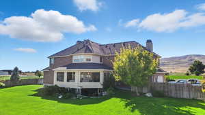 Rear view of property featuring a chimney and a balcony
