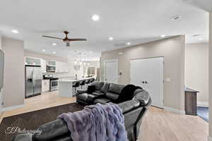 Living room featuring light wood-style floors, recessed lighting, and ceiling fan