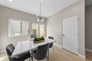 Dining area featuring light wood-style floors, recessed lighting, and a chandelier