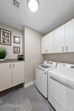 Laundry room with cabinet space and washer and clothes dryer