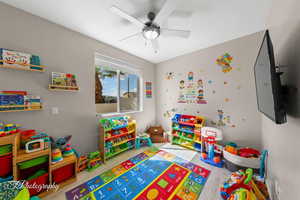 Recreation room with wood finished floors and a ceiling fan