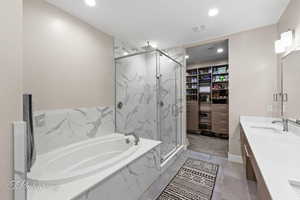 Full bath with a bath, a marble finish shower, double vanity, and recessed lighting