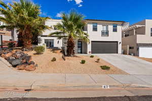 View of front of house featuring stucco siding, concrete driveway, and an attached garage