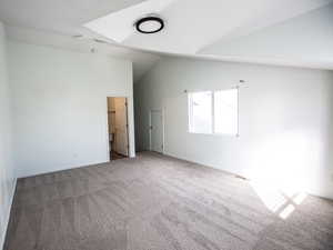 Spare room featuring lofted ceiling and carpet flooring