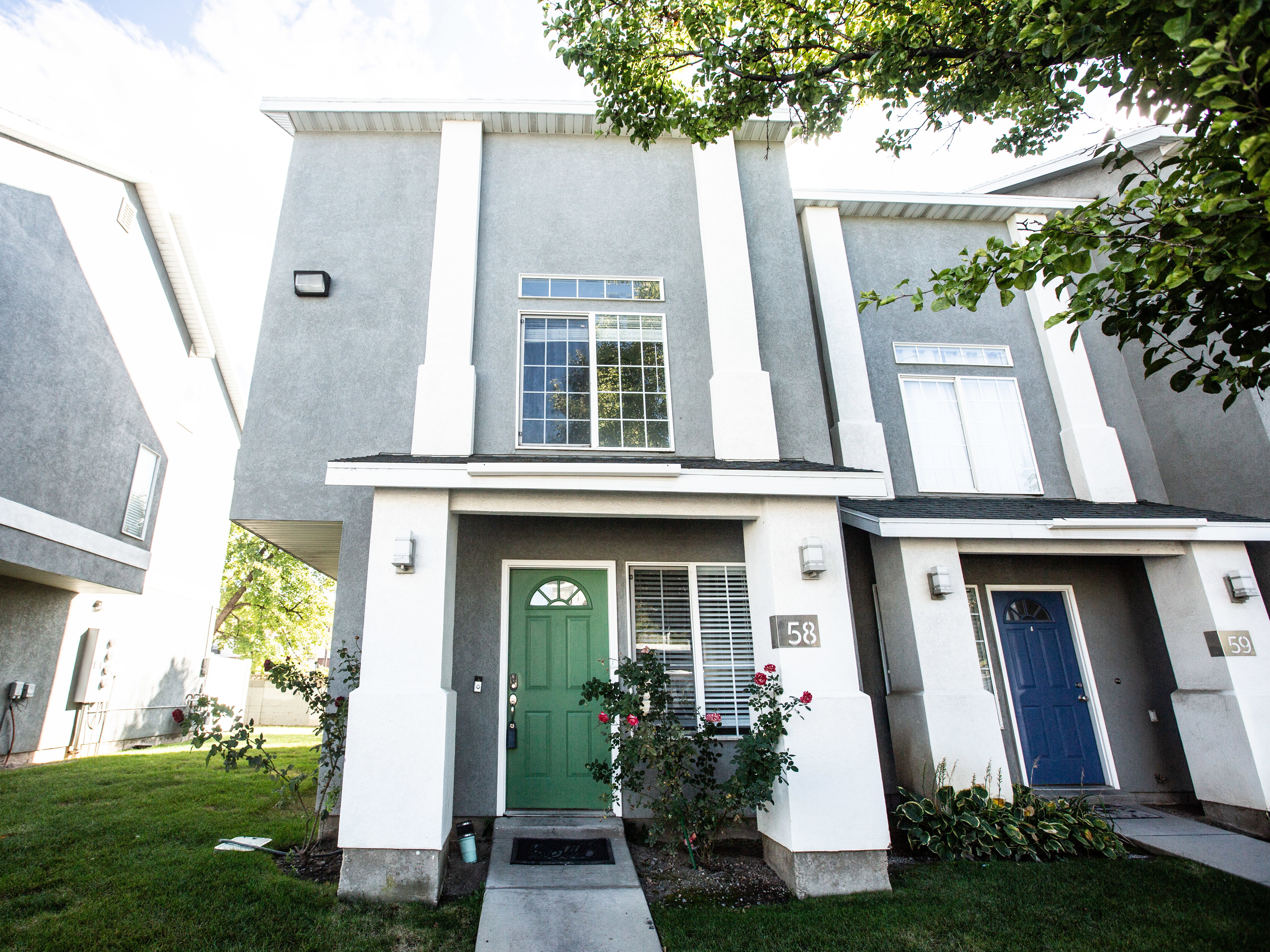 Entrance to property with stucco siding and a lawn