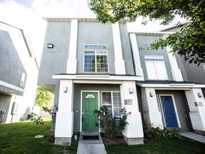 Entrance to property with stucco siding and a lawn