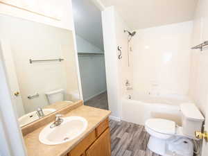 Full bath with bathing tub / shower combination, vanity, and light wood finished floors