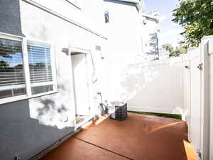 View of side of property with stucco siding and a patio