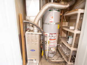 Utility room featuring strapped water heater and heating unit