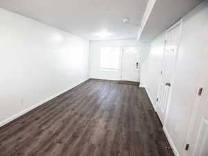 Entryway featuring baseboards and dark wood-style floors