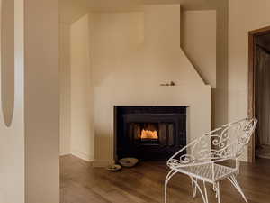 Detailed view of a warm lit fireplace and wood finished floors