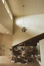 Dining space featuring a high ceiling, wood finished floors, and recessed lighting