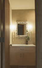 Half bathroom featuring tile walls, vanity, and decorative backsplash
