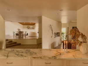 Kitchen featuring recessed lighting, wood finished floors, light brown cabinets, and light stone counters