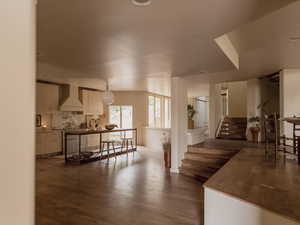 Living room with dark wood-style flooring and stairs