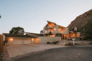View of front of property featuring concrete driveway, a balcony, a garage, and brick siding