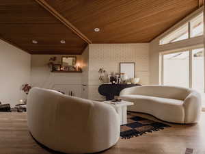 Living area featuring brick wall, wooden ceiling, lofted ceiling, and wood finished floors