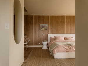 Bedroom featuring wooden walls and wood finished floors