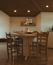 Bar area featuring dark wood finished floors, recessed lighting, open shelves, and wooden ceiling