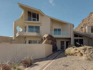 View of front of home with a balcony and brick siding