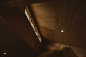Detailed view of wooden ceiling, wooden walls, and recessed lighting