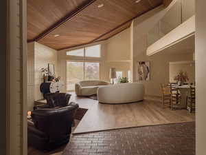 Living room featuring brick floors, high vaulted ceiling, brick wall, and wooden ceiling