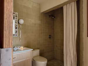 Full bath featuring tile walls and a tile shower