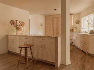 Kitchen featuring light brown cabinets, light wood-style floors, and light stone countertops