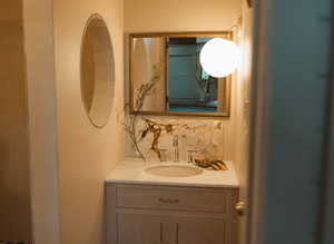 Bathroom featuring vanity and decorative backsplash