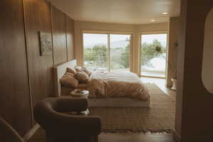 Bedroom featuring wood finished floors, arched walkways, and wooden walls