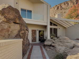 Doorway to property with brick siding and a chimney