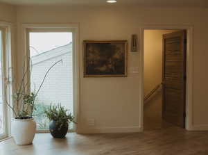 Corridor featuring wood finished floors, an upstairs landing, and recessed lighting