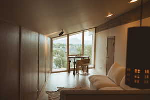 Living room with light wood-style flooring and floor to ceiling windows