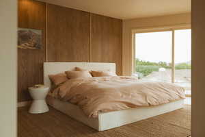 Bedroom featuring access to exterior and wooden walls