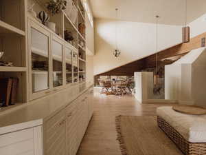 Hallway featuring light wood finished floors and a towering ceiling