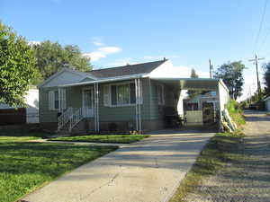 Bungalow-style house featuring driveway, a carport, and a front yard
