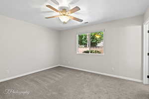 Spare room with light carpet and ceiling fan