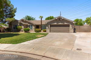 Single story home featuring concrete driveway, stucco siding, a tile roof, and a garage