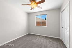 Unfurnished bedroom featuring a closet, carpet floors, and a ceiling fan