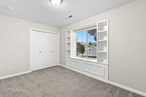 Unfurnished bedroom featuring carpet flooring, a closet, and a textured ceiling
