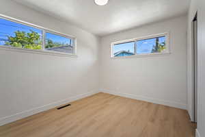 Unfurnished bedroom featuring light wood-style floors, a closet, and a textured ceiling