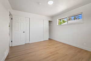 Unfurnished bedroom with two closets and light wood-type flooring