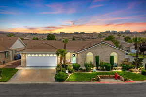 View of front of property with concrete driveway, brick siding, and a garage