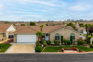 View of front of property featuring driveway, brick siding, an attached garage, a front yard, and a tiled roof