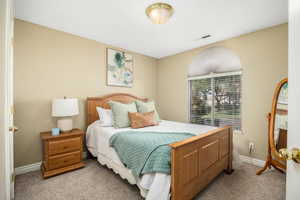 Bedroom with light colored carpet and baseboards